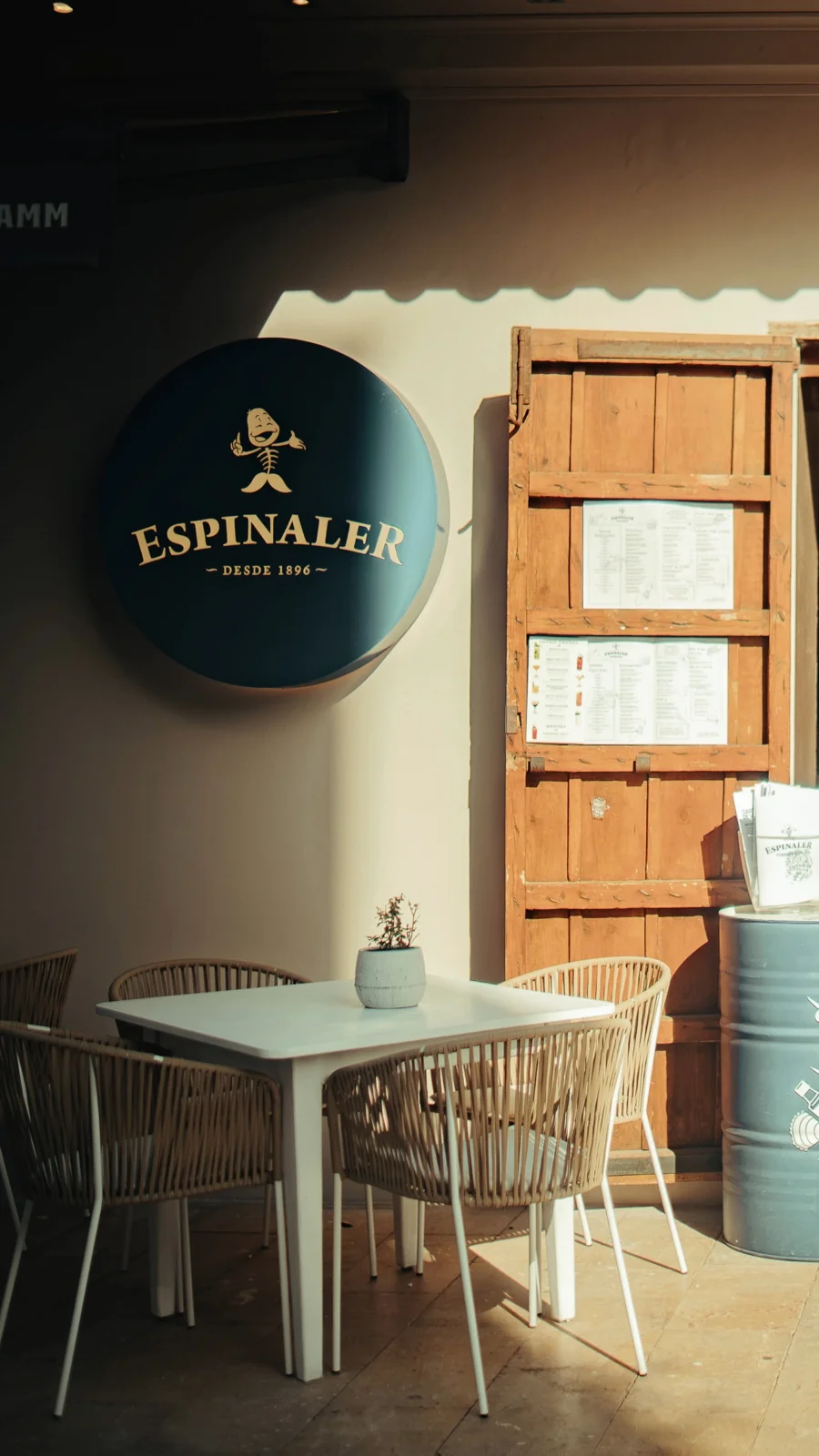 Fachada de Espinaler Formentera con su rótulo circular, la puerta abierta y mesas en la calle